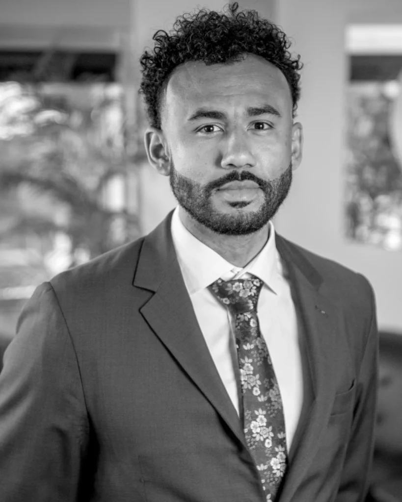Black and white professional headshot of a man in a suit and floral tie